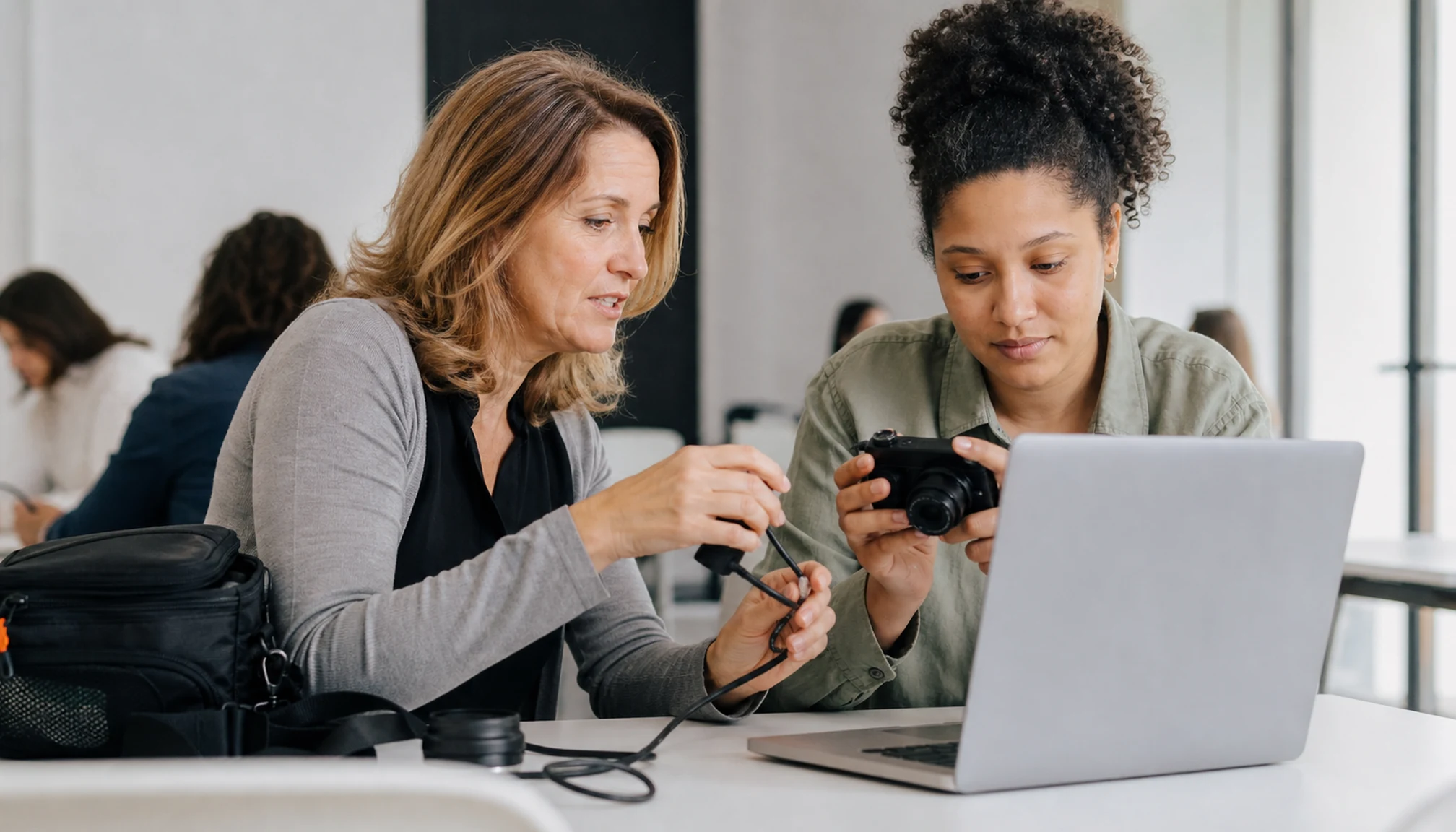 Une formatrice accompagne une participante dans l’utilisation d’un appareil photo numérique